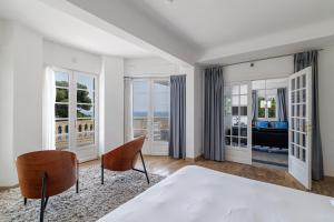 biała sypialnia z łóżkiem i widokiem na ocean w obiekcie Villa Ocean Breeze w mieście Roquebrune-Cap-Martin