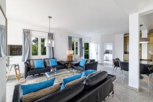 salon z czarnymi skórzanymi kanapami i niebieskimi poduszkami w obiekcie Villa Ocean Breeze w mieście Roquebrune-Cap-Martin