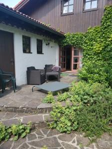a patio in front of a white house at Ferienwohnung - Apartment Sabine - Urlaub mit Hund in Peiting +17 photos