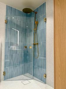 a bathroom with a shower with blue tiles at Apartment in the heart of Ålesund city in Ålesund