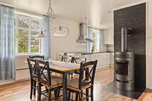 a kitchen with a table and chairs and a stove at Trolltunga Fjord Living in Tyssedal