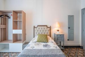 a bedroom with a bed and a dresser and a lamp at Le Parcours Cathare in Olonzac +36 photos