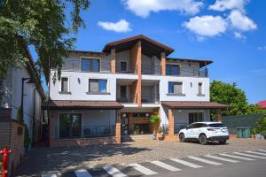 a white car parked in front of a building at First Apartments in Focşani