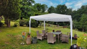a white tent with chairs and a table in a yard at Haus Hönigblick in Wilnsdorf