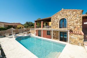 a swimming pool in front of a house at Pretziosa in Castiadas
