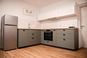 a kitchen with a stainless steel refrigerator and wooden floors at Apartment METULJ in Domžale