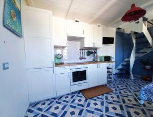 a kitchen with white cabinets and a blue and white tile floor at MinaMare Vacation Home in Torre Annunziata +15 photos
