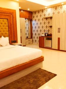 a bedroom with a large bed and a kitchen at Red Rose Resort in Mandarmoni