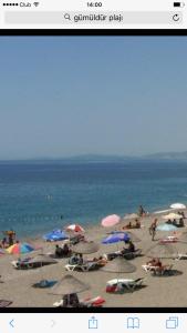 uma foto de uma praia com guarda-sóis e pessoas nela em Hotel Efes em Gumuldur