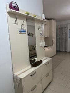 a kitchen with white cabinets and a mirror at Sole Inn Apartment in Durrës +9 photos