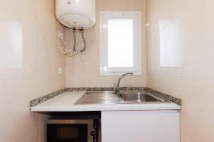 a kitchen with a sink and a window at Centric Rentalmar in Salou +19 photos