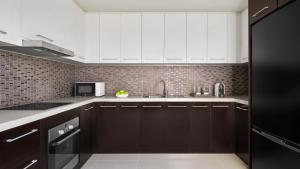 a kitchen with dark brown cabinets and white appliances at InterContinental Residences Nha Trang by IHG in Nha Trang