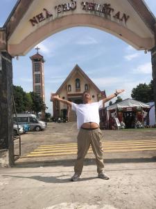 a man standing under an arch with his arms out at Tiamo hose in Kon Rung (1)