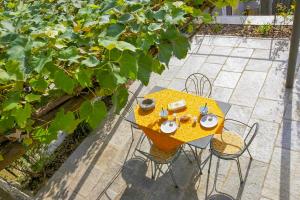 Una vista aérea de una mesa amarilla con sillas en un jardín. en Casa Lumaca, en Cannero Riviera