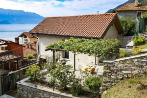 una casa con mesa y sillas en un jardín en Casa Lumaca, en Cannero Riviera