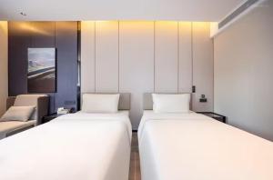 a room with two beds and a couch at Atour Hotel Tianshui North Road Wanda Chengguan Lanzhou in Lanzhou