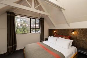 a bedroom with a large bed and a window at Sherwood Queenstown in Queenstown