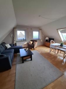 ein Wohnzimmer mit einem blauen Sofa und einem Tisch in der Unterkunft Ferienwohnung Schmettau in Nordstrand