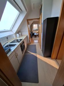 eine kleine Küche mit Spüle und Kühlschrank in der Unterkunft Ferienwohnung Schmettau in Nordstrand