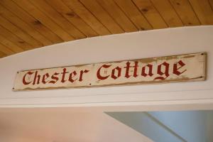 a sign that reads chester cottage on a ceiling at Chester Cottage Beachfront - direct ocean access in Oakura