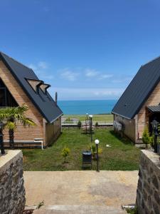 a view of two buildings with the ocean in the background at Azhara Bungalow in Soğuksu +20 photos