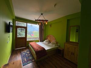 ein grünes Schlafzimmer mit einem Bett und einem Fenster in der Unterkunft Jack of all in Manali + 5 Fotos