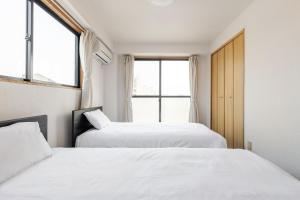 福冈Fieldnever Apartment STAY - Maisonette Family room的有两张床的房间有两扇窗户