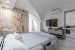 a bedroom with a large bed and a tv at Casa Dolce Vita in Ventimiglia