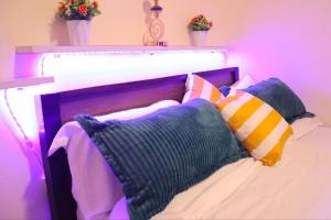 Una cama con almohadas y dos plantas. en Lexus Homes, en Nakuru