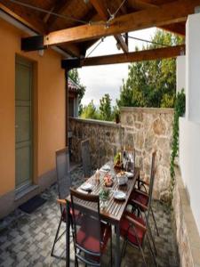 a patio with a table and chairs and a stone wall at Holiday Home Lišnjak in Drniš