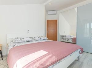 a bedroom with a large bed with a pink blanket at Villa Maria with Outdoor Pool in Drniš +33 photos