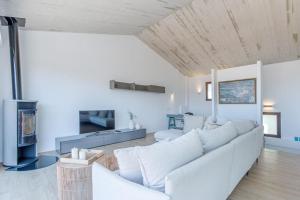 un soggiorno con un divano bianco e una TV di Milenial Immo Exclusive house with sea views Cadaqués a Cadaqués