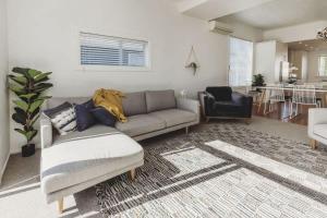 a living room with a couch and a chair at Ropiha Retreat - close to Fitzroy Beach paradise in New Plymouth +11 photos