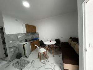 a kitchen with a table and a kitchen with a couch at Apartmani Musić in Ulcinj