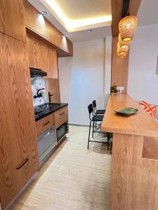 a kitchen with wooden cabinets and a counter top at Urban Nest Agadir - City Center Apartment in Agadir +23 photos