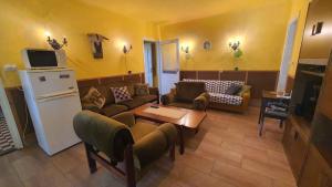 a living room with a couch and a table and a refrigerator at Holiday home in Szantod - Balaton 31357 in Szántód