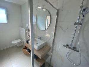 a white bathroom with a sink and a mirror at Villa 6 people, Spa and Sea View in Carantec +25 photos