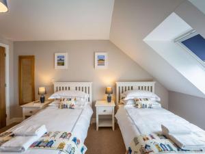 2 camas individuales en un dormitorio del ático con 2 lámparas en 3 Bed in Seahouses 81486, en Seahouses