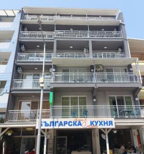 an apartment building with a sign in front of it at Guest house WEST in Sunny Beach