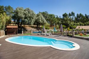 a swimming pool in a yard with a wooden deck at Rural Natura in Leiria