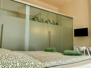 a bedroom with a large bed and a flat screen tv at SMARAGD - Doppelzimmer mit Küche direkt im Zentrum, Balkon in Bad Ischl