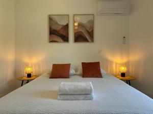 a bedroom with a large white bed with two lamps at Villa Jeanne in Ners