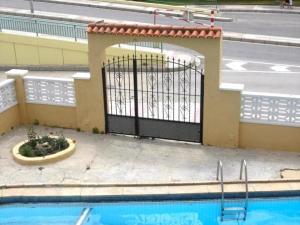 a gate in a building next to a swimming pool at Apartamento Pineda de Mar en Primera Línea in Pineda de Mar