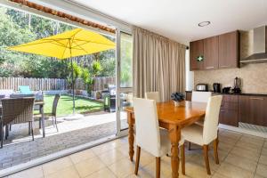 a kitchen and dining room with a wooden table and yellow umbrella at Rural Natura in Leiria