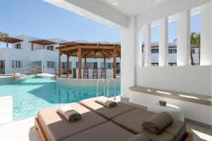 a villa with a swimming pool and a couch at Martini Boutique Resort in Ialysos