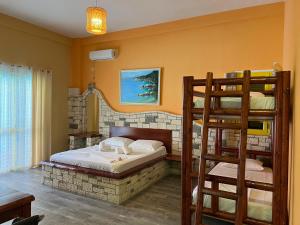 a bedroom with a bunk bed with a ladder at Hotel Adriatik Orikum in Orikum