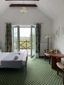 a bedroom with a bed and a sliding glass door at Siedlisko Kierzkowo in Kierzkowo