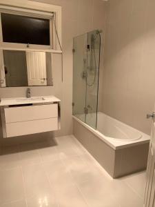 Un baño con bañera, lavabo y ducha. en Yokinebnb, en Perth 9 fotos más