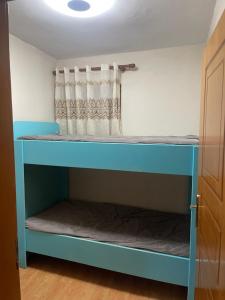 a blue bunk bed in a room with a curtain at Ziu home in Ura Vajgurore