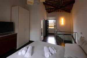 Una habitación con una cama con tres toallas. en La casa di Annetta, en Montalcino 4 fotos más